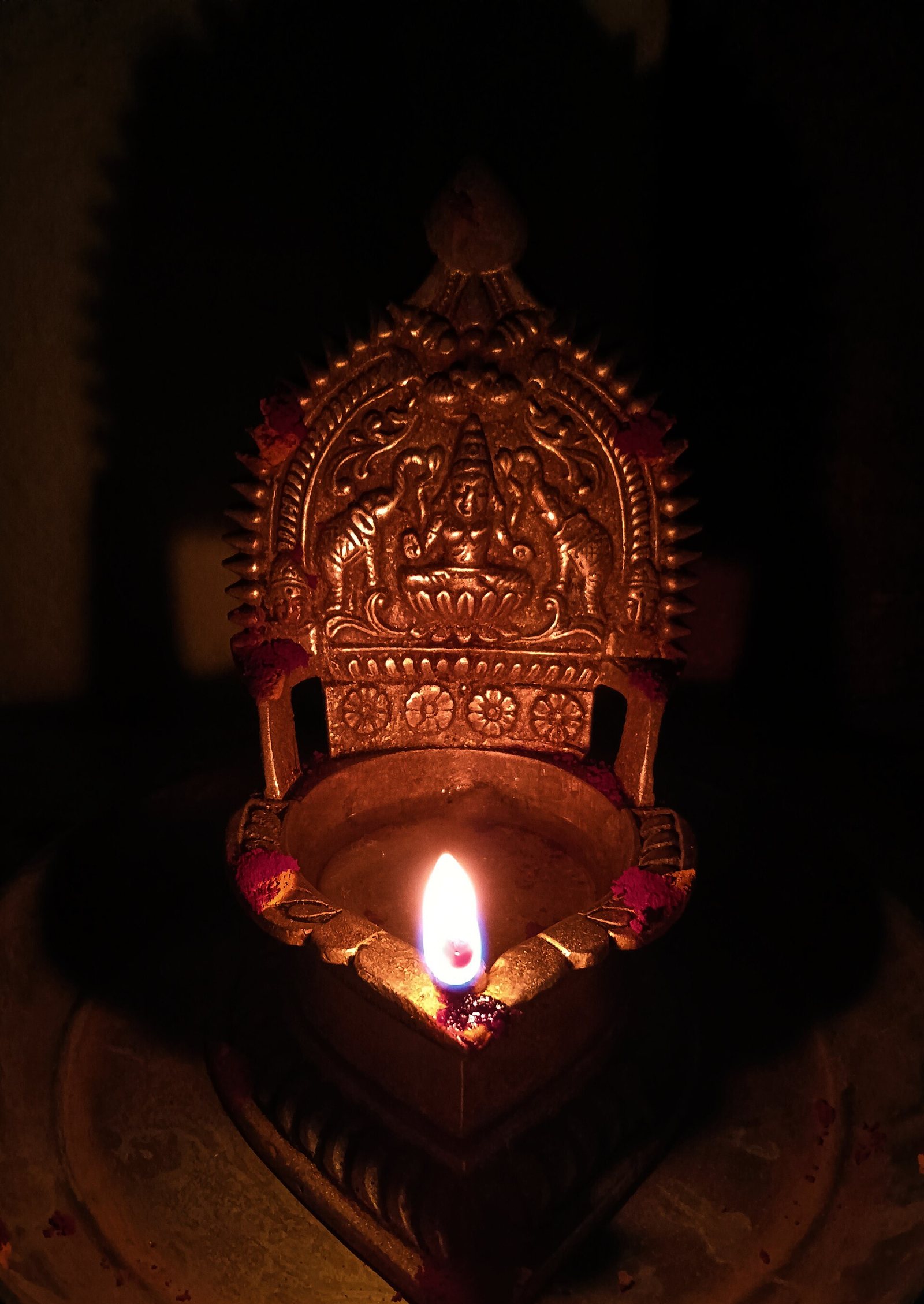 A single lit oil lamp glowing in a dark room